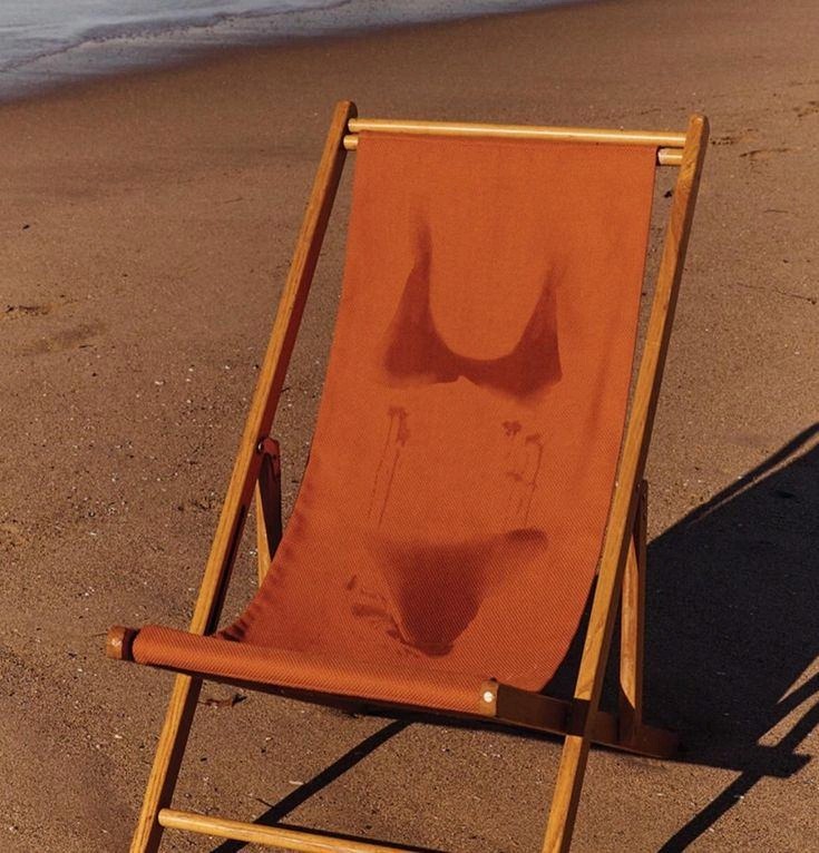 A striped deckchair on empty sand